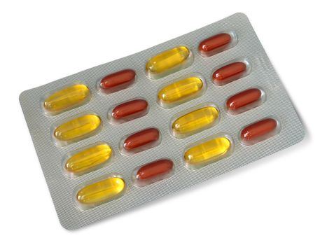Pack of red and yellow vitamin pills isolated over white background