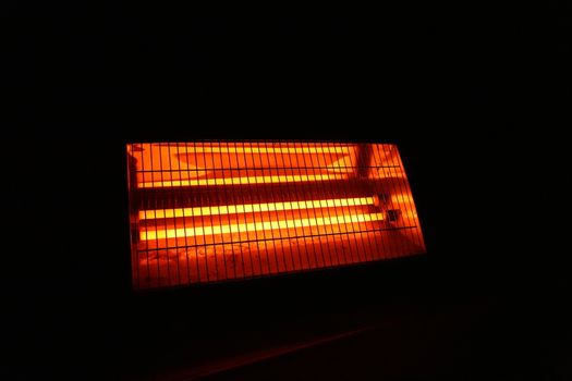 a hot electric heater in a dark room.