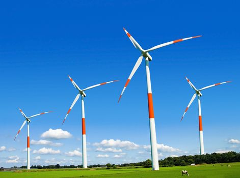 Wind turbines generating electricity on the beautiful green meadow.