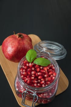 Ripe pomegranate fruit in a jar on wooden vintage background