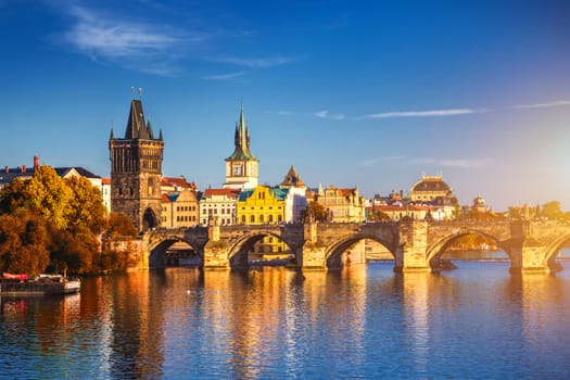View of the Vltava River and Charle bridge with autumn red foliage, Prague, Czech Republic