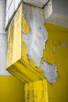 Close up of an old pillar with yellow peeling paint