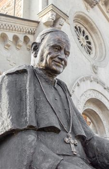 Statue of Pope John XIII with an Italian church in the background