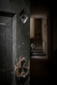 An old half-open door leads to a dimly lit corridor.