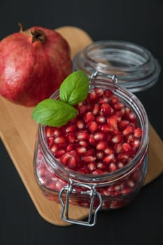 Ripe pomegranate fruit in a jar on wooden vintage background