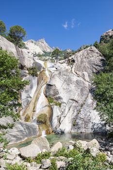 Waterfall and natural pool in the famous Purcaraccia Canyon in Bavella during summer, a tourist destination and attraction (for canyoning and hiking). Corsica, France