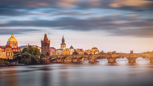 View of the Vltava River and Charle bridge with autumn red foliage, Prague, Czech Republic