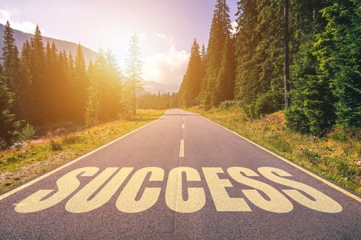 Success word written on road in the mountains