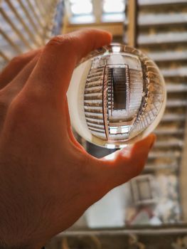 Crystal glass lensball over dirty square spiral staircase in old abandoned hospital