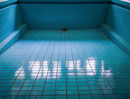 Empty blue swimming pool in old abandoned hospital
