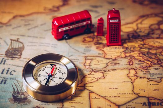 The iconic red bus and Big Ben miniature with compass on the map of London, UK. Concept of travel.