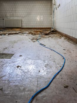 Long blue cable in destroyed hospital room in old abandoned hospital