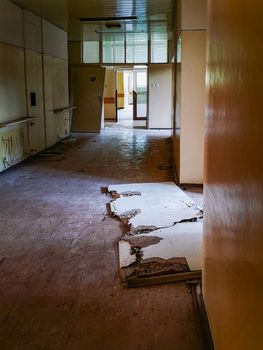 Old destroyed and removed out of frame doors in corridor of old abandoned hospital