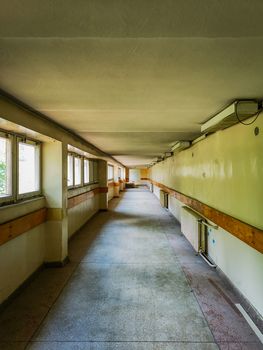 Long old corridor with windows and radiators in old abandoned hospital