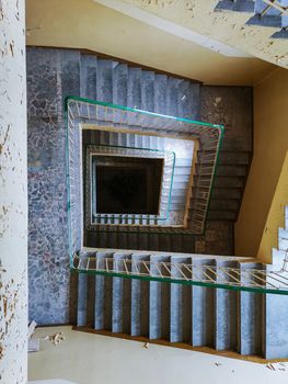 Old square spiral staircase in old abandoned hospital