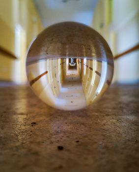 Long corridor of old abandoned hospital reflected in crystal glassy lensball