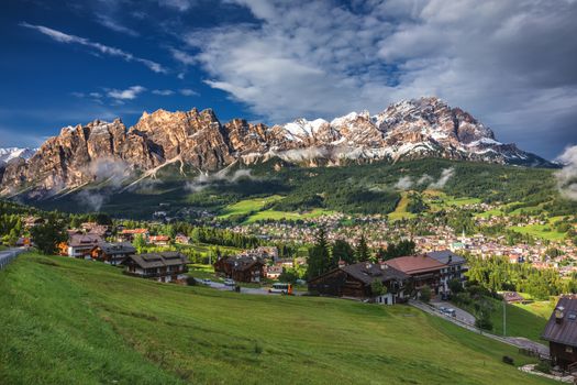 Cortina d'Ampezzo town panoramic view with alpine green landscape and massive Dolomites Alps in the background. Province of Belluno, South Tyrol, Italy.