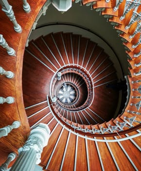 Top down look to Old spiral staircase with ornaments in tenement house 