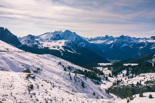 Beautiful winter panorama with fresh powder snow. Landscape with spruce trees, blue sky with sun light and high Alpine mountains on background
