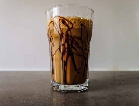 Ice shaked coffee with chocolate souce on glass 