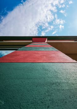 Upward look to colorful red and green pillar and blue cloudy sky