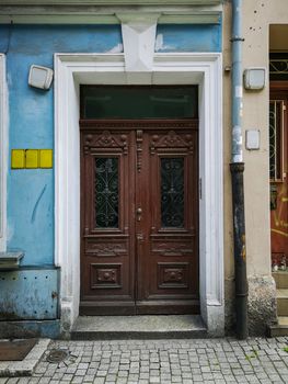 Old brown wooden doors with ornaments of old tenement house 