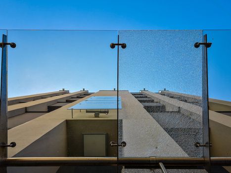 Upward look to crushed glassy ceiling near high building