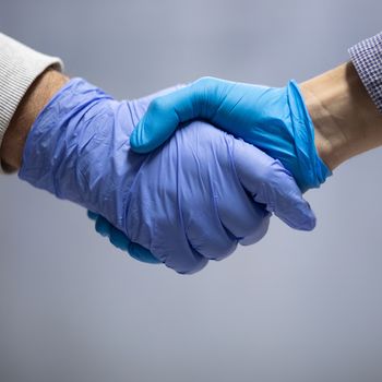 Handshaking with blue protective gloves indoor