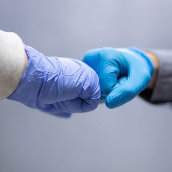 Business colleagues greeting with elbows during coronavirus pandemic. stock photo