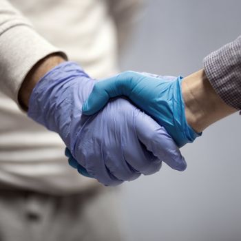 Handshaking with blue protective gloves indoor