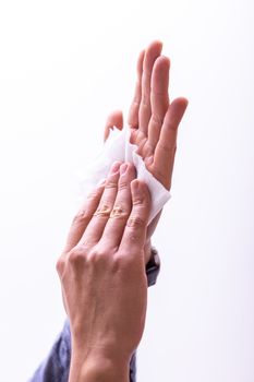 Young man cleaning hands with wet wipes