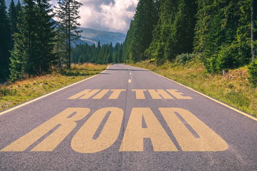 Hit the road words on highway road in the mountains