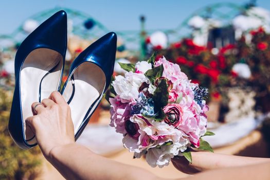 Bride holding bouquet and blue shoes