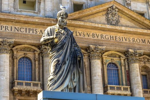 Statue of Saint Peter and Saint Peter's Basilica at background in St. Peter's Square, Vatican City, Rome, Italy