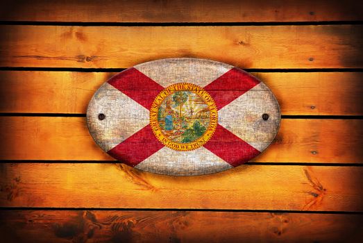 A Florida flag on brown wooden planks.