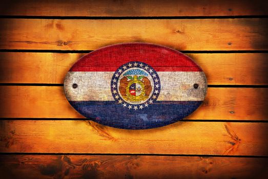 A Missouri flag on brown wooden planks.