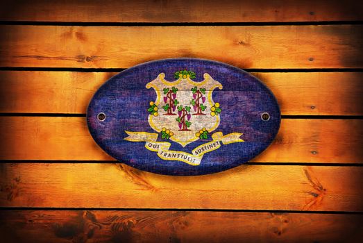 A Connecticut flag on brown wooden planks.