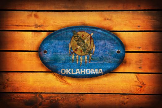 A Oklahoma flag on brown wooden planks.