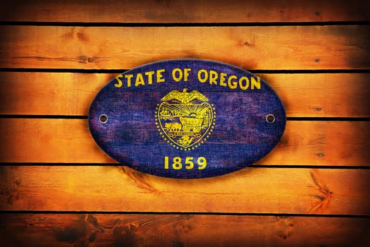 A Oregon flag on brown wooden planks.