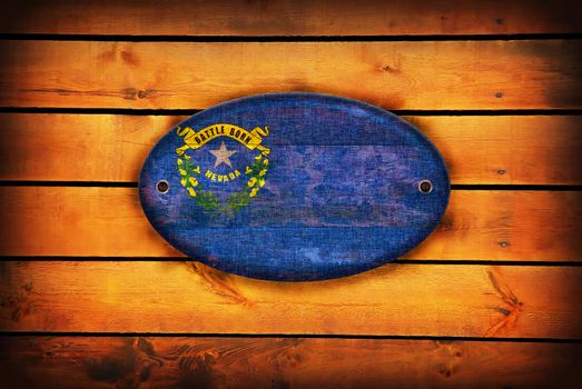 A Nevada flag on brown wooden planks.