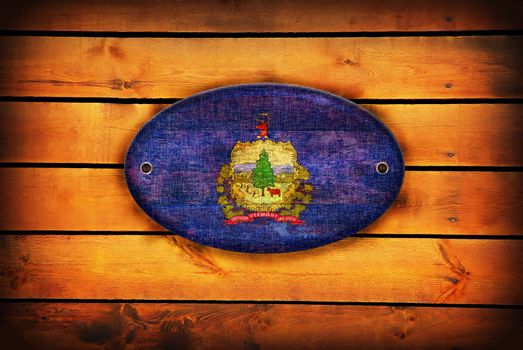 Vermont flag on brown wooden planks.