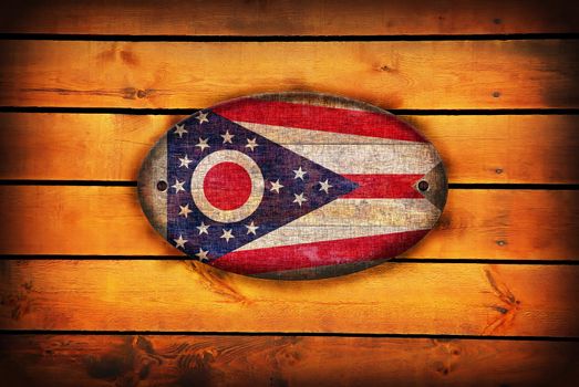 A Ohio flag on brown wooden planks.
