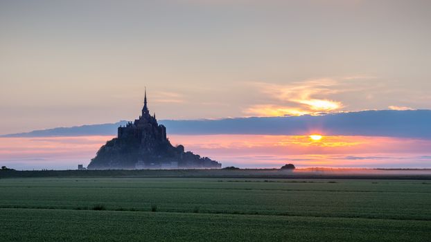 Beautiful panoramic view of famous Le Mont Saint-Michel tidal island at sunrise. Normandy, northern France