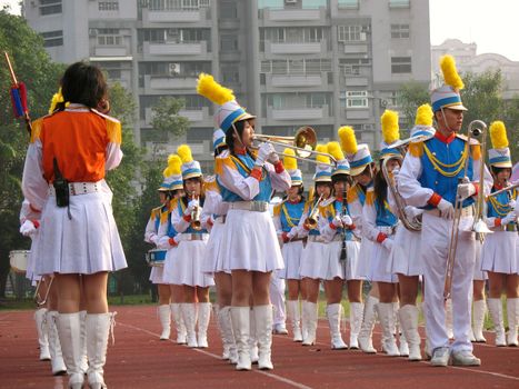 A high school marching band plays variety of brass and wood wind instruments