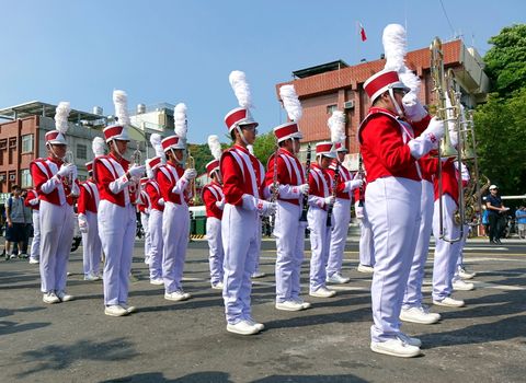 KAOHSIUNG, TAIWAN -- OCTOBER 1, 2017: A high school marching band gets ready to join a street parade at the opening of the 2017 Ecomobility Festival.

