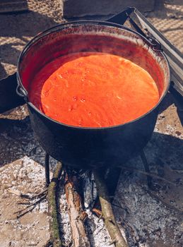 Preparing traditional romanian tomato juice/sause in caldron, boiled and preserved for the winter in a jar.