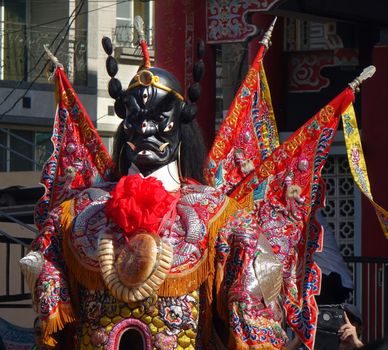 KAOHSIUNG, TAIWAN -- JUNE 10 , 2017: Dancers wear large elaborate masks and costumes that make them extra tall to represent deities popular in Taiwan's folk religion.
