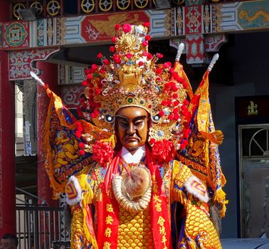 KAOHSIUNG, TAIWAN -- JUNE 10 , 2017: Dancers wear large elaborate masks and costumes that make them extra tall to represent deities popular in Taiwan's folk religion.