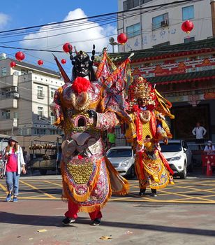 KAOHSIUNG, TAIWAN -- JUNE 10 , 2017: Dancers wear large elaborate masks and costumes that make them extra tall to represent deities popular in Taiwan's folk religion.