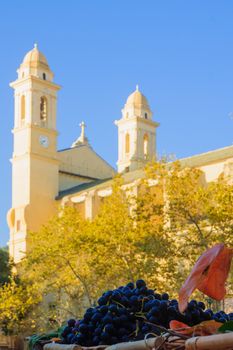 Market product and the Saint John the Baptist church, in place du Marche square, in Bastia, Corsica, France